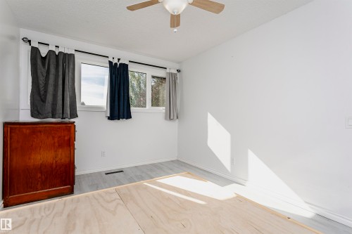 White walls, light wood-finish flooring, and a ceiling fan - 7204 92B Avenue Nw, Edmonton, AB 
