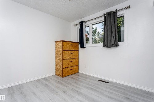 Light gray wood-finish flooring with white walls and trim - 7204 92B Avenue Nw, Edmonton, AB 
