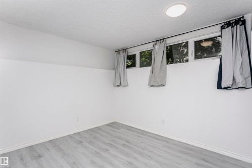 Recessed lighting, wood-finish flooring, white walls, and multiple windows - 7204 92B Avenue Nw, Edmonton, AB 