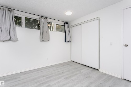 Recessed windows, light wood-finish flooring, sliding closet doors, ceiling-mounted light fixture, and white wall finishes - 7204 92B Avenue Nw, Edmonton, AB 