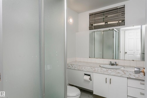 Integrated vanity with an oval sink, white cabinetry, and a full-width mirror - 7204 92B Avenue Nw, Edmonton, AB 