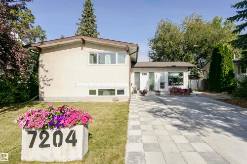 Stucco exterior with a peaked roofline, front lawn, and paved driveway - 7204 92B Avenue Nw, Edmonton, AB 