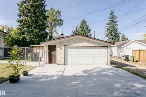 Detached garage featuring a white panel door and a concrete driveway - 7204 92B Avenue Nw, Edmonton, AB 