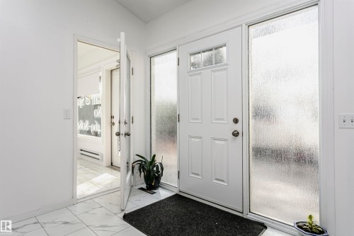 White paneled entry door with transom and textured glass sidelights - 7204 92B Avenue Nw, Edmonton, AB 
