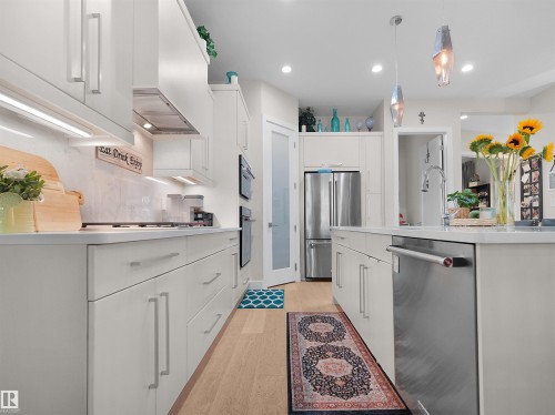 White cabinetry, stainless steel appliances, light wood-finish flooring, recessed lighting, and pendant lighting - 904 Wood Place Nw, Edmonton, AB 