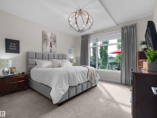 Tray ceiling with a contemporary chandelier and large windows - 904 Wood Place Nw, Edmonton, AB 