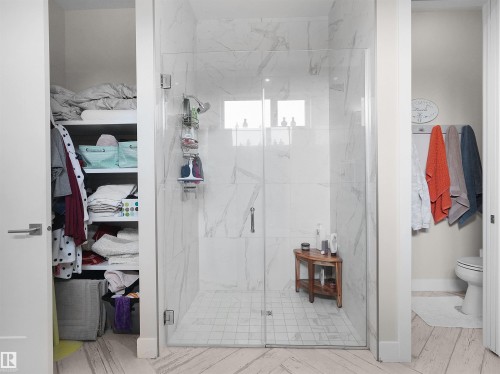Glass-enclosed shower with large format tile walls and a mosaic tile floor - 904 Wood Place Nw, Edmonton, AB 