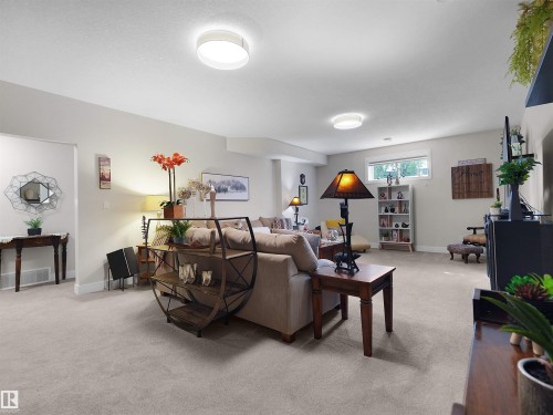 Recessed lighting illuminating a carpeted living space with neutral wall tones and a high window - 904 Wood Place Nw, Edmonton, AB 