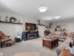Recessed lighting, wall-mounted shelving, built-in entertainment center, and integrated electric fireplace - 