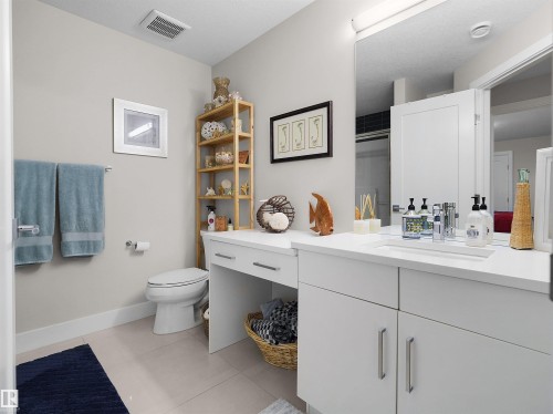 White vanity with an integrated sink and brushed nickel hardware, complemented by a built-in makeup counter - 904 Wood Place Nw, Edmonton, AB 