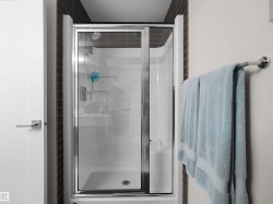 Shower enclosure with sliding glass doors and chrome hardware - 