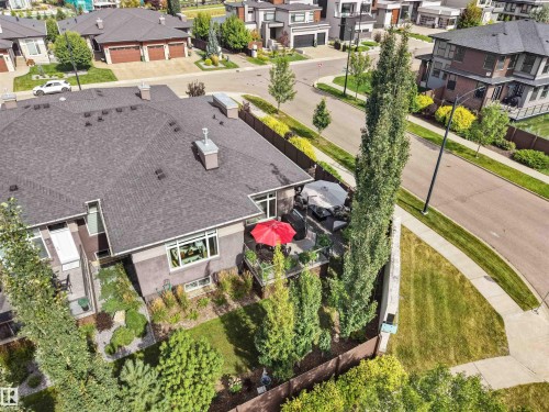 Multi-level residence featuring a dark shingle roof, a balcony with a glass railing, and a ground-level patio area - 904 Wood Place Nw, Edmonton, AB 