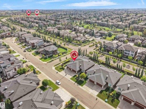 Residential area featuring numerous houses with dark shingle roofs, mature trees, and paved streets - 904 Wood Place Nw, Edmonton, AB 