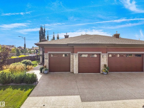 Three-car garage with wood-finish doors and transom windows - 904 Wood Place Nw, Edmonton, AB 