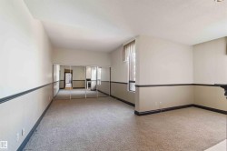 Wall-to-wall carpeting, mirrored closet doors, and a window with vertical blinds - 