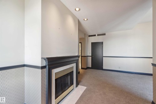 Recessed lighting, dark wood-finish mantel, fireplace with a metal insert, patterned wainscoting, and carpet flooring - #12A 10050 118 St Nw, Edmonton, AB 
