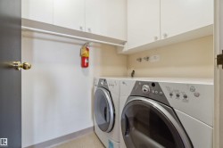 Laundry area featuring white cabinetry, a built-in hanging rod, and a neutral wall finish - 