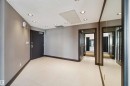 Recessed ceiling lighting, light-toned tile flooring, mirror-paneled wall, dark wood trim, and multiple doorways - #12A 10050 118 St Nw, Edmonton, AB 