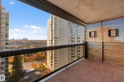 Balcony featuring brick flooring, a glass railing, wood slat privacy screens, and a natural scenery backdrop - 