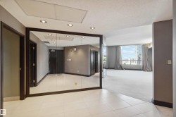Full-height mirror wall with dark wood trim, recessed ceiling lighting, light-colored tile flooring, and carpeted flooring in an open concept area - 