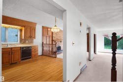 Kitchen featuring wood cabinetry, integrated dishwasher, and wood-finish flooring - 