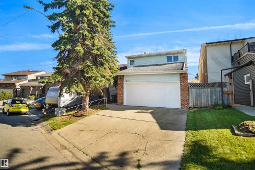 Two-story residence featuring light blue siding and brick accents - 12311 25 Avenue Nw, Edmonton, AB 