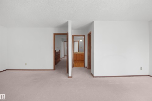 Wall-to-wall carpeting with light-toned walls and wood trim - 12311 25 Avenue Nw, Edmonton, AB 