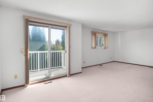 Spacious room with white walls and light-colored carpeting - 12311 25 Avenue Nw, Edmonton, AB 