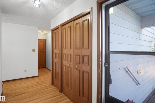 Hardwood flooring throughout, multiple solid wood panel doors, and a ceiling-mounted light fixture - 12311 25 Avenue Nw, Edmonton, AB 