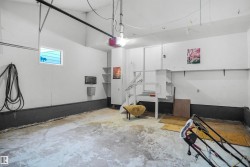 Garage with concrete flooring, built-in shelving, and a small window - 