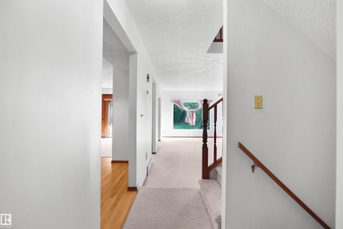 Carpeted hallway with wood-finish flooring - 12311 25 Avenue Nw, Edmonton, AB 