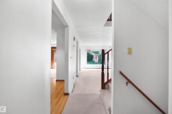 Carpeted hallway with wood-finish flooring - 