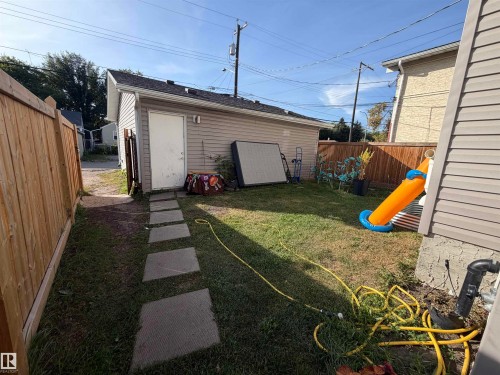 Detached garage featuring horizontal siding and a side entry door - 11442 82 Street Nw, Edmonton, AB 