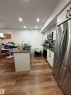 Wood-finish flooring throughout, complemented by recessed ceiling lighting - 11442 82 Street Nw, Edmonton, AB 