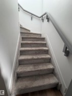 Carpeted staircase with contemporary grey handrail - 