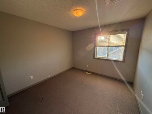 Recessed window with blinds, wall-to-wall carpeting, and flush mount ceiling light fixture - 7065 Cardinal Way Sw, Edmonton, AB 