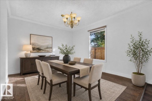 Dark wood-finish flooring, crown molding, and a multi-light chandelier - 8 Wahstao Crescent Nw, Edmonton, AB 
