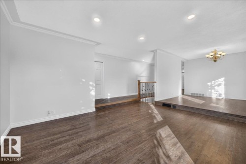 Wood-finish flooring throughout, recessed lighting, crown molding, and a built-in staircase with a wooden handrail - 8 Wahstao Crescent Nw, Edmonton, AB 