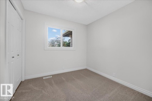 White painted walls with white trim, a double bi-fold closet, and a single window with white framing - 8 Wahstao Crescent Nw, Edmonton, AB 