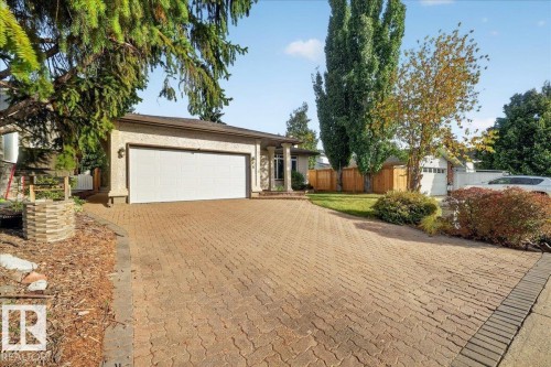 Exterior featuring a double garage, stucco siding, and a paver driveway - 8 Wahstao Crescent Nw, Edmonton, AB 