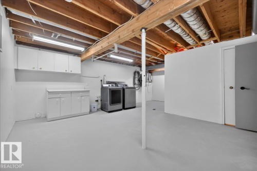 Utility Room with exposed wood joists, utility sink, and built-in white cabinetry - 8 Wahstao Crescent Nw, Edmonton, AB 