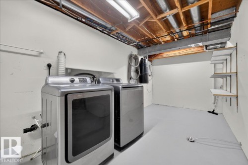 Laundry area with exposed ceiling joists, overhead lighting, and built-in wall shelving - 8 Wahstao Crescent Nw, Edmonton, AB 