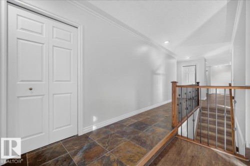 Hardwood flooring, tiled flooring, white trim, recessed lighting, and a wood and wrought iron staircase - 8 Wahstao Crescent Nw, Edmonton, AB 