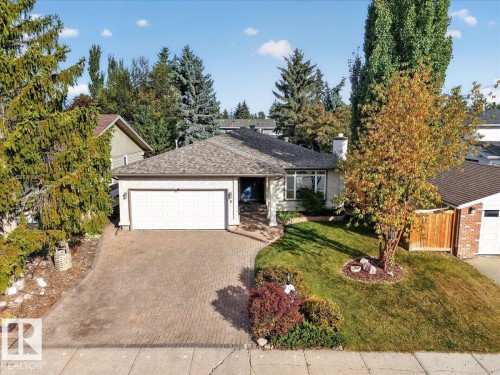 Paved driveway, attached garage, shingled roof, front lawn, and mature trees - 8 Wahstao Crescent Nw, Edmonton, AB 