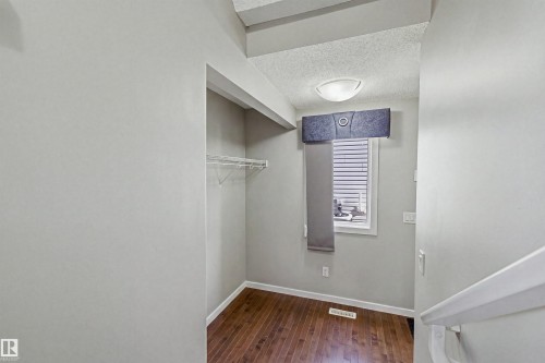 Windowed alcove featuring wood-finish flooring, a wire shelving unit, and an overhead flush-mount light fixture - 3151 Trelle Loop Nw, Edmonton, AB 