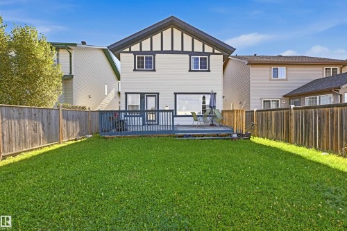 Expansive backyard featuring a green lawn, wood fence, and a multi-level wood deck - 3151 Trelle Loop Nw, Edmonton, AB 