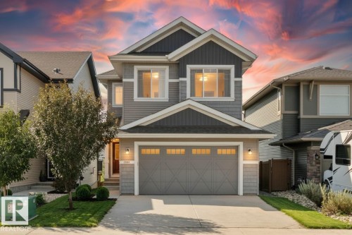 Two-story home with a two-car garage, gray siding, and a gabled roof - 3334 Parker Loop Sw, Edmonton, AB 