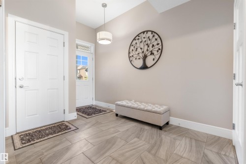 Entryway featuring light-toned walls, tile flooring, and a contemporary pendant light fixture - 3334 Parker Loop Sw, Edmonton, AB 
