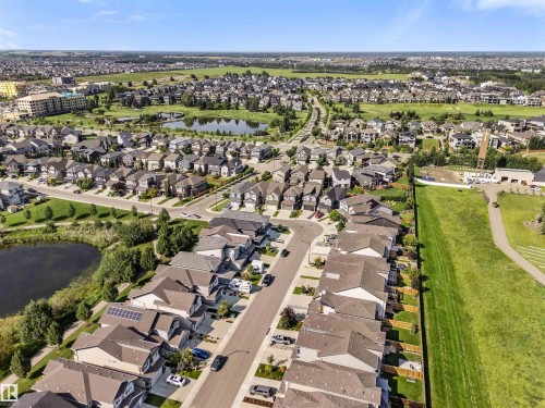 Expansive suburban neighborhood with numerous residential properties, abundant green spaces, multiple water features, and a clear sky backdrop - 3334 Parker Loop Sw, Edmonton, AB 