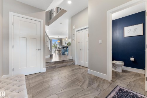 Light-toned tile flooring, white interior doors, and a built-in closet with bifold doors - 3334 Parker Loop Sw, Edmonton, AB 